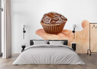 Homemade chocolate brown muffins in a hand. isolated on white background Wall mural