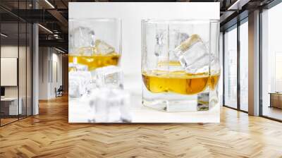 Two glasses of scotch whiskey with ice cubes, white background, wooden backdrop Wall mural