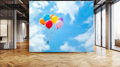 Colorful balloons floating high in a blue sky, representing freedom, joy, and happiness. Wall mural