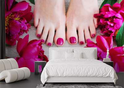 Feet with pink pedicure and peonies, top view Wall mural