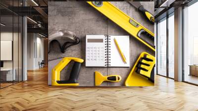 Contractor theme. Tool kit of the contractor: yellow hardhat, libella and tools on the gray tiles background. Wall mural