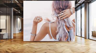 beautiful young boho woman close up with pink feathers and accessories at sunset Wall mural