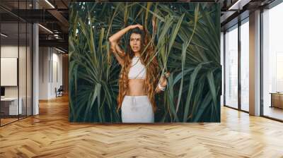 beautiful young stylish woman at tropical leaves background Wall mural