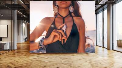 beautiful young tribal style woman holding sea shell outdoors at sunset close up Wall mural