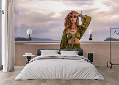 beautiful young woman in stylish costume on the beach at sunset Wall mural