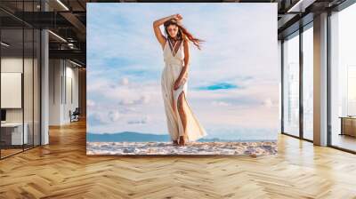 beautiful young woman on the beach at sunset Wall mural