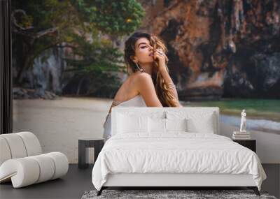 beautiful young woman on the beach with rock background Wall mural