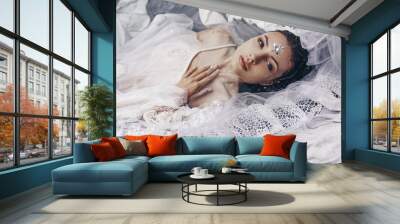 portrait of beautiful woman lying in water with fabric. Fashion concept Wall mural