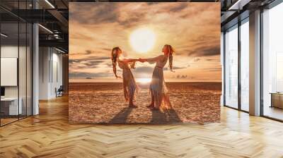 two beautiful girls having fun at sunset on the beach Wall mural