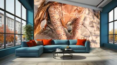 young fashionable woman sitting on the stone beach portrait Wall mural