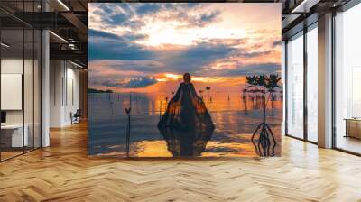 young woman standing in water at sunset silhouette Wall mural