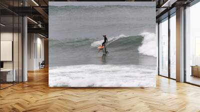 Surfers taking waves and resting in Barceloneta beach in Barcelona Wall mural