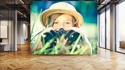 beautiful young explorer girl with hat and binocular at park Wall mural