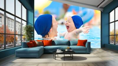 happy child and mom with swimming pool cap have fun in a pool Wall mural