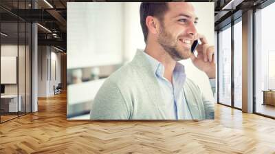 smiling young casual businessman talking on the phone at office Wall mural