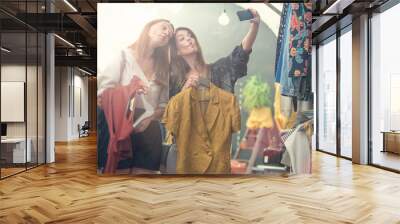 Two smiling friends enjoy in clothing shop Wall mural