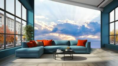 Rays of the sun shine in the sky through the dramatic blue clouds  Wall mural