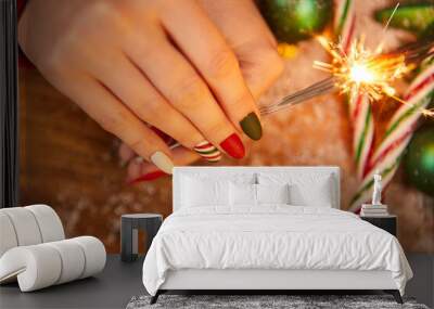 Festive decorations and sparklers in the hand of a woman Wall mural