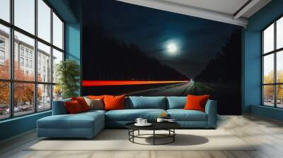 Light trails from vehicles traveling on rural road, surrounded by two rows of trees, late at night with moon on sky. Wall mural