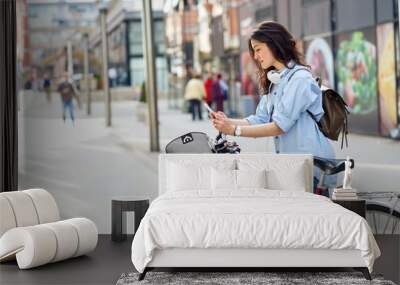 Beautiful young woman with bicycle in urban environment. Wall mural