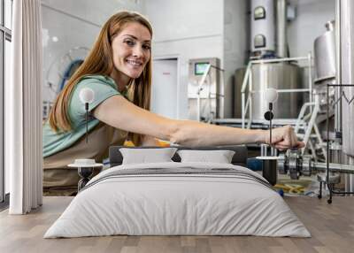 Female brewer working in craft brewery. Wall mural