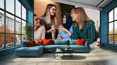 Group of modern multicultural young women in casual wear discussing architectural designs in the creative office.	 Wall mural