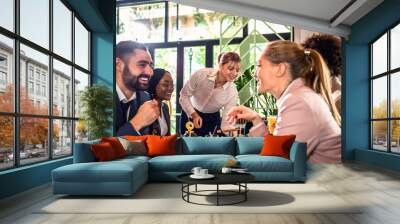 Smiling waitress serving meal to group of business people in restaurant. Wall mural