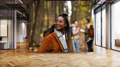 Three female friends having fun and enjoying hiking in forest. Wall mural