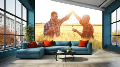 Two farmer standing in a wheat field. they are happy with yield of wheat. Wall mural