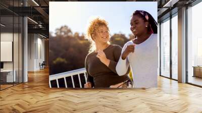 Two young plus size women jogging together. Wall mural