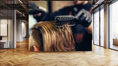 Barber drying male hair in hairdressing salon. Wall mural