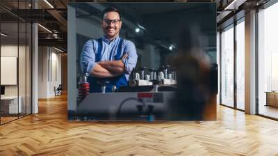 Cheerful factory worker with arms crossed. Wall mural