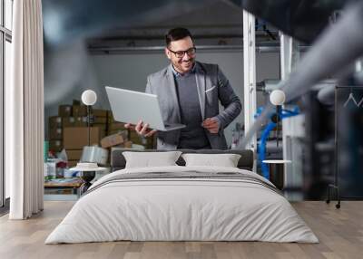 Engineer in the factory using laptop computer for maintenance. Wall mural