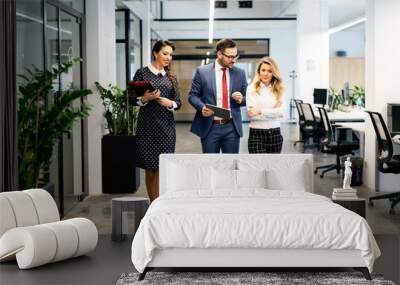 Full length of group of happy young business people walking the corridor in office together Wall mural