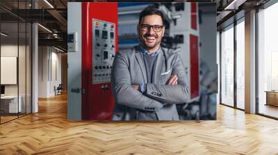 Industrial manager indoors in factory.Young businessman posing in factory. Wall mural