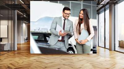 Professional salesperson selling cars at dealership to buyer Wall mural