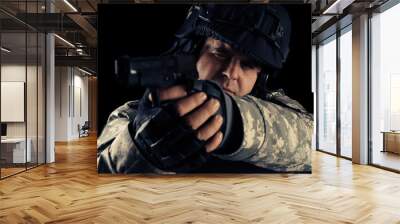 Soldier aiming with black pistol. Image on a dark background.  Wall mural