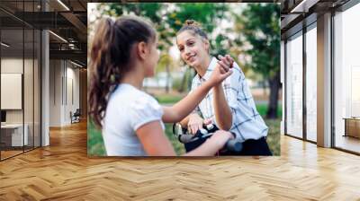 Two girls greeting each other with a high five. Wall mural