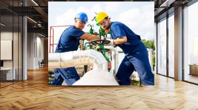 Two petrochemical workers inspecting pressure valves on a fuel tank Wall mural