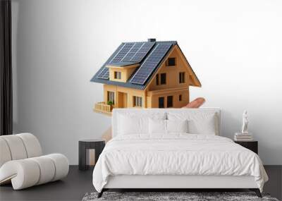 A hand holding a model house with solar panels in bright light Wall mural