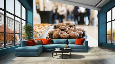 Chocolate muffins on table with people in background at hotel lobby. Wall mural