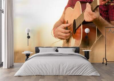 Close up of male hands playing acoustic guitar on the wheat field at the sunset. Retro, music, lifestyle concepts. Wall mural