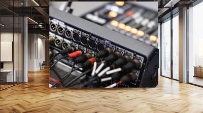 Close-up view of audio mixing console with cables connected during a live event setup process Wall mural