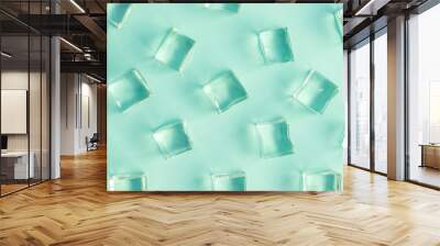 Flat lay of ice cubes on bright green background minimal drink and summer concept. Wall mural