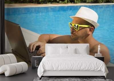 man working on laptop at the swimming pool edge Wall mural