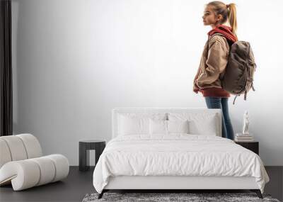 Young student standing with backpack in casual attire against blank background Wall mural