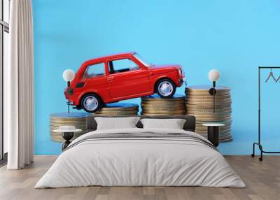 Red miniature car on coin stack Wall mural