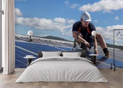 Solar panel technician with drill installing solar panels Wall mural