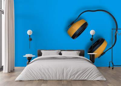 Construction, anti-noise headphones. Background with yellow headphones. Wall mural