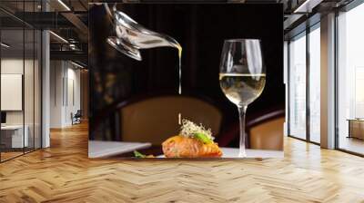 beautiful serving dishes in the restaurant, red fish salmon with vegetables on a white plate in a restaurant on a black background with white wine stokanom Wall mural